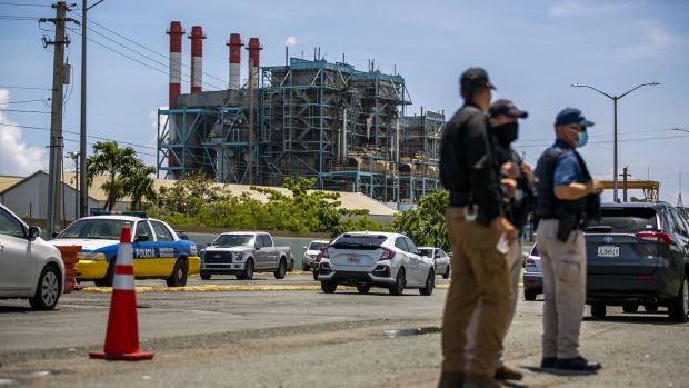 Police offers stand guard near demonstrators blocking the entrance to a Luma Energy facility at the Puerto Rico Electric Authority (Prepa) Palo Seco Power Plant in Toa Baja, Puerto Rico, on Friday June 4, 2021. Luma Energy -- a consortium of Atco Ltd. and Quanta Services Inc. working with Innovative Emergency Management Inc. -- took over the operation and management of the Puerto Rico Electric Power Authority's transmission and distribution lines on June 1.