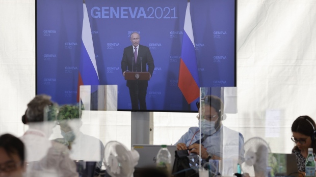 Members of the media watch a broadcast feed of Vladimir Putin, Russia's president, speaking during a press conference following the U.S. Russia summit at Villa La Grange in Geneva, Switzerland, on Wednesday, June 16, 2021. Joe Biden and Vladimir Putin kick off what could be more than four hours of meetings on Wednesday afternoon in Geneva, with officials from both countries keeping expectations low for any breakthrough agreement. Photographer: Stefan Wermuth/Bloomberg