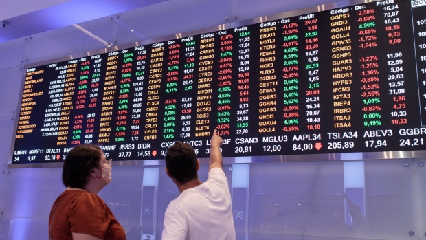 A visitor points to an electronic board displaying stock activity at the Brasil Bolsa Balcao (B3) stock exchange in Sao Paulo, Brazil, on Monday, Nov. 8, 2021. The Ibovespa opened 0.2 percent lower at 104,627.30 in Sao Paulo, with Brasil Bolsa Balcao contributing the most to the index decline, decreasing 1.9 percent. Photographer: Patricia Monteiro/Bloomberg