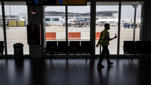 A member of ground crew at a gate at Budapest Ferenc Liszt International Airport in Budapest, Hungary, on Wednesday, Aug. 4, 2021. The Hungarian government has made a non-binding offer to buy Budapest Airport, according to people familiar with the matter, as Prime Minister Viktor Orban seeks to gain control of what had been one of the fastest growing hubs in the region before the coronavirus pandemic. Photographer: Akos Stiller/Bloomberg
