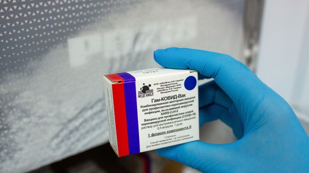 A health worker removes a box containing vials of the 'Gam-COVID-Vac', also known as 'Sputnik V', COVID-19 vaccine, developed by the Gamaleya National Research Center for Epidemiology and Microbiology and the Russian Direct Investment Fund (RDIF), from cold storage during a trial at the City Clinic #2 in Moscow, Russia, on Thursday, Nov. 26, 2020. Developers of Russia’s flagship vaccine, Sputnik V, said that initial testing showed it was 91.4% effective in preventing infections, although it has not yet published final results in a peer-reviewed journal. Photographer: Andrey Rudakov/Bloomberg