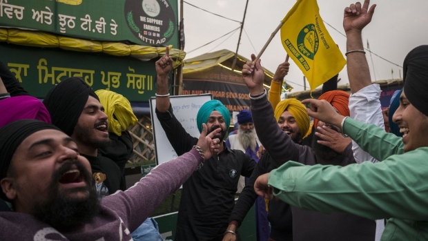 Farmers celebrate at a protest site on the Delhi-Haryana border crossing in Singhu, Delhi, India, on Friday, Nov. 19, 2021. Indian Prime Minister Narendra Modi made his biggest policy reversal since assuming power in 2014, scrapping controversial farm laws ahead of crucial state elections following a year of persistent street protests.