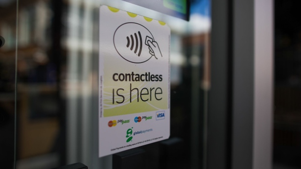A contactless payment sticker sits displayed in the window of a restaurant in Norwich, U.K., on Tuesday, June 9, 2020. With the economy on course for its deepest recession for at least a century, the government is now paying the wages of more than 10 million workers to stave off mass unemployment. Photographer: Chris Ratcliffe/Bloomberg
