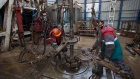 Workers fit drilling pipes at the rotary table of an oil drilling rig, operated by Tatneft PJSC, on an oilfield near Almetyevsk, Tatarstan, Russia, on Wednesday, March 6, 2019. Tatneft explores for, produces, refines, and markets crude oil.