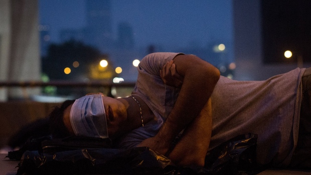 HONG KONG - OCTOBER 05: A pro-democracy protester sleeps on a concrete road divider on a street outside the Hong Kong Government Complex on October 5, 2014 in Hong Kong, Hong Kong. Thousands of pro-democracy supporters continue to occupy the streets surrounding Hong Kong's Financial district despite demands from Hong Kong Chief Executive Leung Chun-ying to clear the area before Monday, October 6. The protesters are calling for open elections and the resignation of Hong Kong's Chief Executive Leung Chun-ying. (Photo by Chris McGrath/Getty Images)