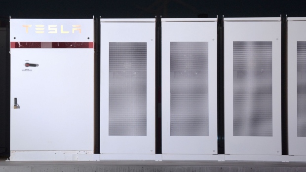Tesla Inc. Powerpacks that will be used to form the world's largest lithium-ion battery stand on display at the Hornsdale wind farm, operated by Neoen SAS, near Jamestown, South Australia, on Friday, Sept. 29, 2017. Against a backdrop of wind turbines 150 miles (241 kilometers) north of Adelaide, Tesla Chief Executive Officer Elon Musk announced a contract to build the world's largest lithium-ion battery system had been signed with South Australia's power distributor, triggering a 100-day self-imposed deadline to install the electricity storage system.