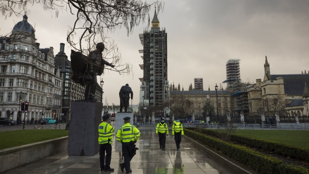 Police officers stand outside the Houses of Parliament in London, U.K., on Monday, Dec. 14, 2020. London Mayor Sadiq Khan called for schools in the capital to close to stem a rising tide of coronavirus infections that threatens to push the city into the governments tightest pandemic rules. Photographer: Jason Alden/Bloomberg