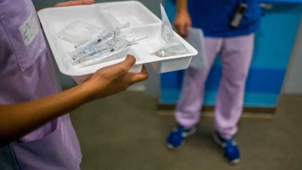 Healthcare workers prepare third doses of the Pfizer-BioNTech Covid-19 vaccine at a senior-living facility in Paris, France, on Thursday, Sept. 16, 2021. France is on the forefront of a carrot-and-stick approach that seeks to maintain a high level of vaccinations.