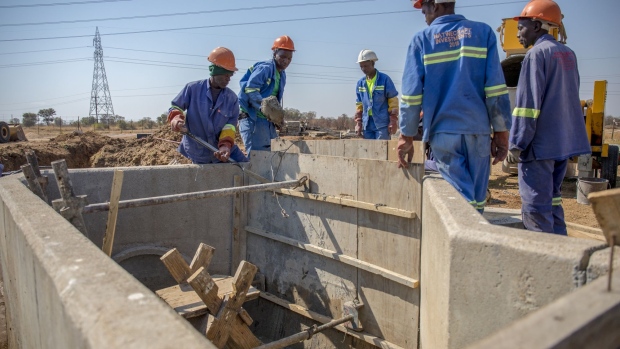 Construction workers build a wall at Southern Areas sewage treatment site to harvest raw affluent and raw water in Bulawayo, Zimbabwe, on Friday, Aug. 2, 2019. Zimbabwe is in the grip of a nationwide drought that’s depleted dams, cut output by hydropower plants, caused harvests to fail and prompted the government to appeal for $464 million in aid to stave off famine. Photographer: Cynthia R Matonhodze/Bloomberg