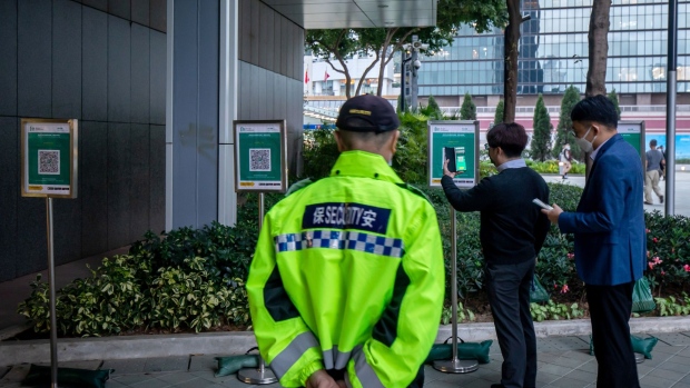 People show their health code to a security guard before entering a shopping area in Beijing, China, on Tuesday, Jan. 26, 2021. Beijing’s municipality is targeting gross domestic product growth of more than 6% this year, Beijing Daily reported, citing the city’s mayor.