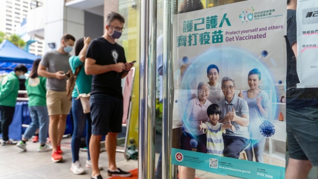 A poster advertising the vaccination program outside a community vaccination center administering the BioNTech Covid-19 vaccine imported by Fosun Pharma in Hong Kong, China, on Monday, April 26, 2021. Hong Kong saw a jump in bookings for coronavirus vaccine appointments after eligibility was widened to all residents aged 16 and older, as the city works to boost inoculation rates seen as crucial to achieving herd immunity.