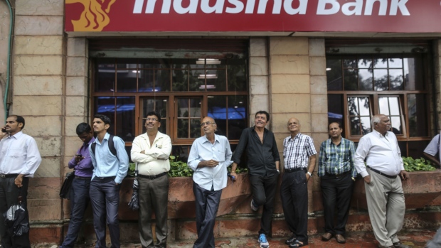 People stand outside a branch of IndusInd Bank Ltd., near the Bombay Stock Exchange (BSE) in Mumbai, India, on Wednesday, Oct. 5, 2016. Reserve Bank of India Governor Urjit Patel surprised many with a rate cut on October 4, signaling that faster expansion has become the priority even as inflation remains stubbornly higher than in the rest of Asia. Three government-appointed economists and two RBI colleagues joined Patel in a 6-0 vote in favor of the quarter-point move.