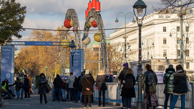VIENNA, AUSTRIA - NOVEMBER 24: People line up at an 'Impfbox' (vaccination box) at City Hall square on the third day of a nationwide, temporary lockdown during the fourth wave of the novel coronavirus pandemic on November 24, 2021 in Vienna, Austria. The measure, in which people are only allowed to leave home for essentials and to go to school or work, is meant by authorities to rein in COVID-19 infections that have skyrocketed in recent weeks. The lockdown is currently scheduled to last until December 13. (Photo by Thomas Kronsteiner/Getty Images)