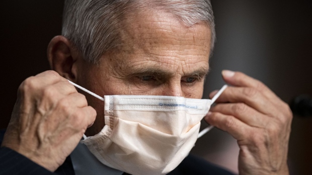 Anthony Fauci, director of the National Institute of Allergy and Infectious Diseases, puts on a protective mask during a Senate Health, Education, Labor, and Pensions Committee hearing in Washington, D.C., U.S., on Thursday, Nov. 4, 2021. Younger children across the U.S. are now eligible to receive Pfizer's Covid-19 vaccine, after the head of the Centers for Disease Control and Prevention this week granted the final clearance needed for shots to begin.