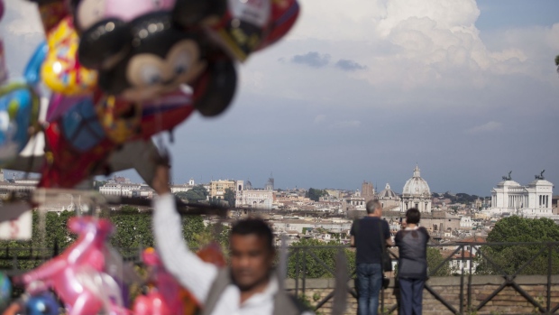 Visitors look across the skyline as a balloon seller passes by in Rome, Italy, on Friday, May 11, 2018. An Italian populist government is likely to water down plans for greater spending and any anti-euro rhetoric, a flip for investors in the nation’s assets, market analysts say.