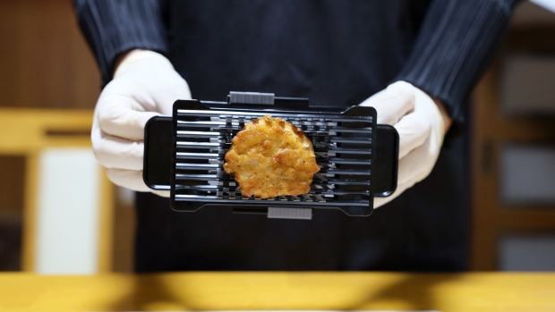 A piece of fried chicken is "stamped" with a special cutter before cooked in the DeliSofter, a $410 specialized steam cooker, at the Gifmo Co. office in Kyoto, Japan, on Tuesday, Nov. 9, 2021. Tokie Mizuno and Megumi Ogawa, two Panasonic Corp. engineer, led the creation of the spin-off company to sell the product that promises to restore a sense of normalcy to elderly people's lives and diets by allowing them to mash food with their tongue alone. Photographer: Kosuke Okahara/Bloomberg