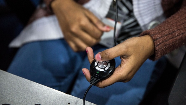 An employee makes a phone call while working at the Avise Techno Solutions LLP call center in Kolkata, India, on Sunday, Dec. 24, 2017. India's political stability and reform push -- including a nationwide consumption tax -- prompted a first upgrade of its sovereign rating in 14 years from Moody's Investors Service in November. Photograph: Taylor Weidman/Bloomberg Photographer: Taylor Weidman/Bloomberg