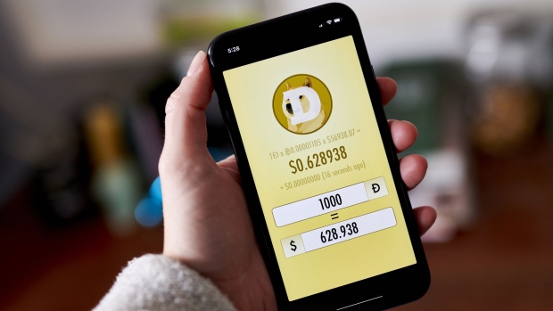 The Dogecoin website on a smartphone arranged in the Brooklyn borough of New York, U.S., on Friday, May 7, 2021. Dogecoin, a cryptocurrency conceived as a joke but now the world's fifth-most valuable, plunged from an all-time high after its most famous cheerleader, Elon Musk, jokingly called it "a hustle" on late-night TV.