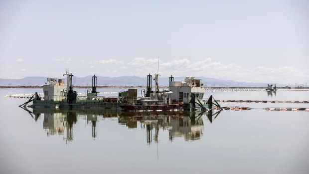 A barge pumps brine from an evaporation pond at Qinghai Lake. Photographer: Qilai Shen/Bloomberg