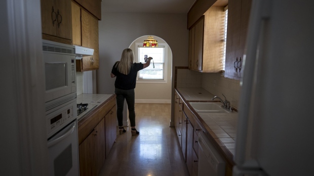 A realtor wearing a protective mask uses a smartphone to provide a virtual video tour of a home for sale in Sacramento, California.