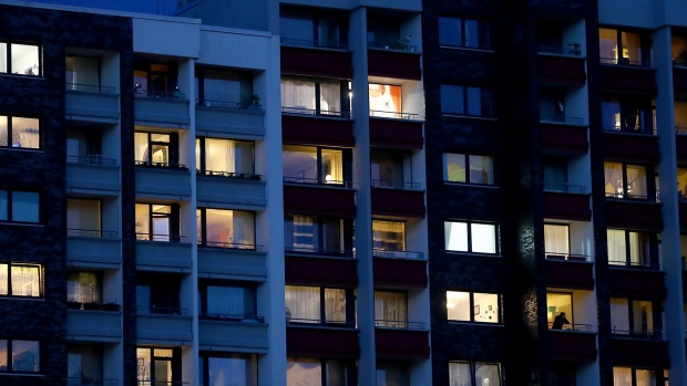 TORNESCH, GERMANY - MARCH 24: Light pours from windows in a residential apartment building during the early evening on March 24, 2020 in Tornesch near Hamburg, Germany. Due to heavy restrictions imposed by authorities on public life in an effort to slow the spread of the coronavirus, including the temporary shuttering of restaurants and bars, most people across Germany are currently staying home in the evenings. (Photo by Martin Rose/Getty Images)