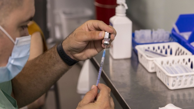 A health worker prepares a booster dose of the Pfizer-BioNTech Covid-19 vaccine at Ichilov medical center in Tel Aviv, Israel, on Monday, Aug. 2, 2021. Israel is now giving seniors a booster dose of vaccine to help control the recent uptick in cases. Photographer: Kobi Wolf/Bloomberg
