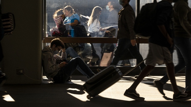 Travelers at San Francisco International Airport (SFO) in San Francisco, California, U.S., on Wednesday, Nov. 24, 2021. Air traffic for the Thanksgiving holiday is expected to approach pre-pandemic levels and travelers are likely considering their plans with some dread, given fresh memories about thousands of canceled flights. Photographer: David Paul Morris/Bloomberg