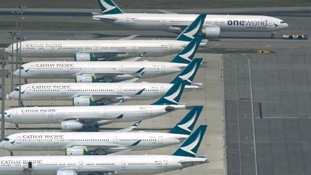 An aircraft operated by Cathay Pacific Airways Ltd., top, taxis on the tarmac passing the company's other aircraft at Hong Kong International Airport in Hong Kong, China, on Wednesday, Oct. 21, 2020. Cathay Pacific will cut about 5,300 jobs based in Hong Kong and and close its Cathay Dragon unit as part of a sweeping overhaul of the city's flag carrier triggered by the halt in air travel due to the coronavirus pandemic. Photographer: Roy Liu/Bloomberg