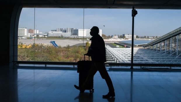 An airline passenger wheels his luggage through Paris-Charles de Gaulle airport in Paris, France, on Monday, Nov. 8, 2021. The U.S. is lifting entry restrictions for more than 30 countries, allowing fully vaccinated travelers to fly from places including Europe, China and India. Photographer: Nathan Laine/Bloomberg