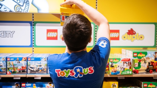 An employee arranges a display of Lego A/S toys inside a Toys "R" Us Inc. store in Paramus, New Jersey, U.S., on Tuesday, Nov. 26, 2019. The new store in the Garden State Plaza is the first of 10 locations planned to be operational by the end of next year. Photographer: Mark Kauzlarich/Bloomberg