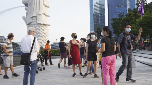 Tourists walk in the Marina Bay area of Singapore, on Saturday, Sept. 25, 2021. Daily infection levels have been ticking higher since the Singaporean government signaled a shift in its Covid strategy, from wiping out all cases to accepting the virus is endemic.