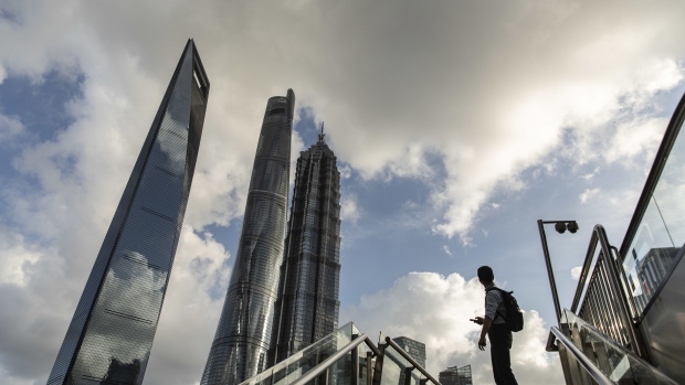 A pedestrians pauses on a footbridge in the Lujiazui business district in Shanghai, China, on Tuesday, July 20, 2021. Banks in China kept the benchmark loan rate unchanged, indicating that the central bank is continuing to keep policy stable despite a recent surprise move to add liquidity to the financial system. Photographer: Qilai Shen/Bloomberg