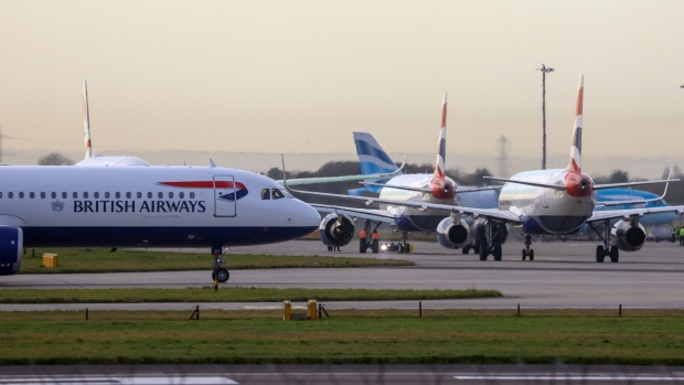 British Airways passenger aircraft outside Terminal 5 at London Heathrow Airport in London, U.K., on Monday, Nov. 8, 2021. The U.S. is lifting entry restrictions for more than 30 countries, allowing fully vaccinated travelers to fly from places including Europe, China and India. Photographer: Chris Ratcliffe/Bloomberg