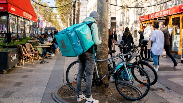 A food delivery courier for Deliveroo Plc on the Champs Elysees in Paris, France, on Wednesday, Nov. 10, 2021. French President Emmanuel Macron sought to rally the French and encourage them to get vaccinated while presenting a bright outlook for the economy in a national address five months before the presidential election.