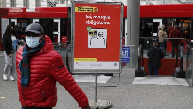 A sign advising the need for face masks outside a tram stop in Bern, Switzerland, on Thursday, Feb. 4, 2021. Swiss National Bank President Thomas Jordan says business shutdowns to contain the pandemic mean economic growth in the final quarter of 2020 and the first quarter of this year will be weak, according to interview with broadcaster SRF. Photographer: Stefan Wermuth/Bloomberg