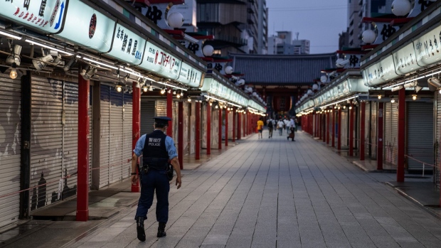 TOKYO, JAPAN - AUGUST 26: A police officer wearing a face mask patrols along Nakamise shopping street on August 26, 2021 in Tokyo, Japan. Japan suspended the use of 1.63 million doses of Moderna Covid-19 vaccines today after reports that some of the vials contained unspecified contaminants. (Photo by Carl Court/Getty Images)