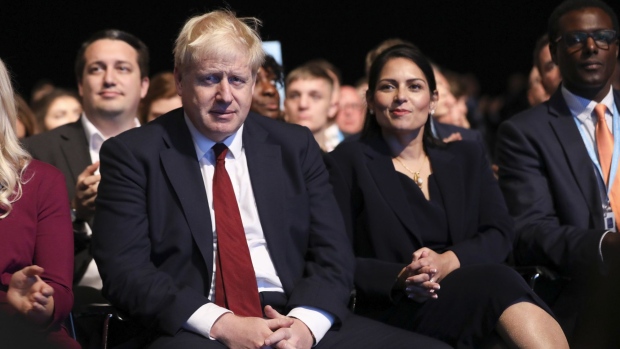 Boris Johnson, U.K. prime minister, left, and Priti Patel, U.K. home secretary, right, attend day two of the annual Conservative Party conference at Manchester Central in Manchester, U.K., on Monday, Sept. 30, 2019. U.K. Prime Minister Boris Johnson hoped to use his party's annual convention to launch his campaign to win the next British general election.
