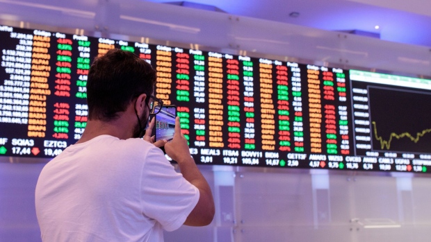 A visitor takes a photograph of an electronic board displaying stock activity at the Brasil Bolsa Balcao (B3) stock exchange in Sao Paulo, Brazil, on Monday, Nov. 8, 2021. The Ibovespa opened 0.2 percent lower at 104,627.30 in Sao Paulo, with Brasil Bolsa Balcao contributing the most to the index decline, decreasing 1.9 percent. Photographer: Patricia Monteiro/Bloomberg