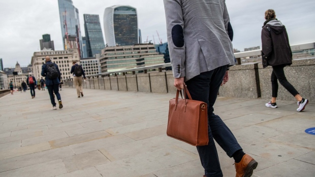 Commuters make their way over London Bridge towards the City of London, U.K., on Thursday, Sept. 30, 2021. Officials have flagged concerns about the labor market after the end of the government’s furlough plan, while households are also facing looming increases in their tax and energy bills that economists say could hurt confidence and reduce the opportunity for hikes. Photographer: Chris J. Ratcliffe/Bloomberg