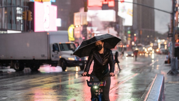 A bicyclist during a rain storm in the Times Square neighborhood of New York. Photographer: Jeenah Moon/Bloomberg