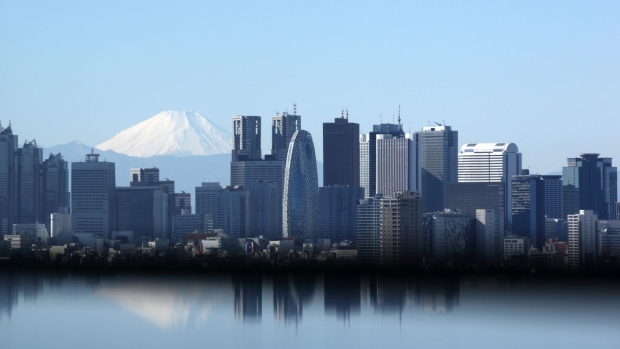 Mount Fuji stands behind buildings in Tokyo.
