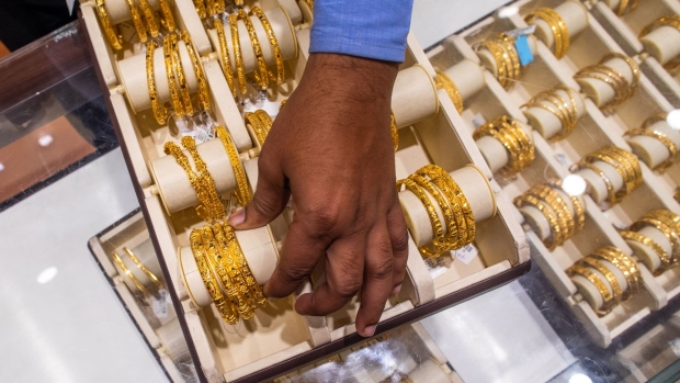 An employee displays gold bracelets inside a Kalyan Jewellers store during the festival of Dhanteras in Noida, India, on Friday, Nov. 13, 2020. India's main holiday season -- culminating Saturday with Diwali, the festival of lights -- appears to be giving a much needed boost to demand, with online retail sales to business activity indicators signalling Asias third-largest economy is recovering. Photographer: Prashanth Vishwanathan/Bloomberg