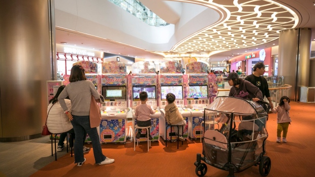 SEOUL, SOUTH KOREA - MARCH 09: (SOUTH KOREA OUT) A family with a baby stroller walks by as South Korean children play the game inside a shopping mall on March 09, 2019 in Seoul, South Korea. Concerned South Korean parents send their kids to play at indoor playgrounds rather than outdoor ones as the fine dust levels in Korea are getting worse and threatening the children's health. (Photo by Jean Chung/Getty Images) Photographer: Jean Chung/Getty Images AsiaPac
