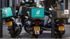 Motor scooters with boxes for Deliveroo, operated by Roofoods Ltd., left and center, stands next to a motor scooter with a box for UberEats, operated by Uber Technologies Inc., as their drivers wait for food orders in London, U.K., on Thursday, Dec. 22, 2016. The food delivery business model has proven attractive to venture capitalists, who last year poured $5.5 billion into food-delivery companies globally, according to research firm CB Insights.