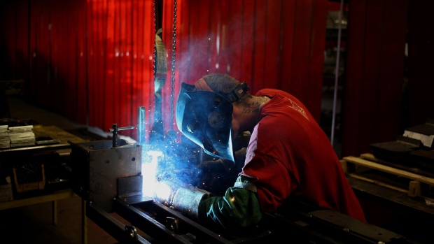 A worker welds a lawnmower frame together on the assembly line at a facility in Coatesville, Indiana. Photographer: Luke Sharrett/Bloomberg