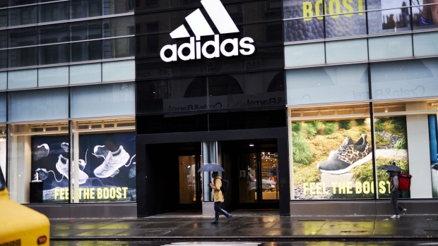 A pedestrian carrying an umbrella passes in front of an Adidas AG store in the SoHo neighborhood of New York, U.S., on Monday, Dec. 14, 2020. The U.S. Census Bureau is scheduled to release retail sales figures on December 16. Photographer: Gabby Jones/Bloomberg
