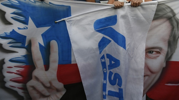 Supporters of Jose Antonio Kast, presidential candidate of the Republican party, hold banners during an election night rally in Santiago, Chile, on Sunday, Nov. 21, 2021. Conservative Chilean presidential candidate Kast and leftist rival Gabriel Boric will square off in a runoff next month, setting the stage for the most divisive election since the return of democracy in 1990. Photographer: Tamara Merino/Bloomberg
