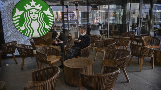 BEIJING, CHINA - MARCH 10: Chinese men wear protective masks as they sit in a nearly empty Starbucks in Sanlitun on March 10, 2020 in Beijing, China. The number of cases of the deadly new coronavirus COVID-19 being treated in China dropped to below 18,000 in mainland China Sunday, in what the World Health Organization (WHO) declared a global public health emergency last month. China continued to lock down the city of Wuhan, the epicentre of the virus, in an effort to contain the spread of the pneumonia-like disease. Officials in Beijing have put in place a mandatory 14 day quarantine for all people returning to the capital from other places in China and countries with a large number of cases like South Korea and Japan. The number of those who have died from the virus in China climbed to over 3140 on Tuesday, mostly in Hubei province, and cases have been reported in many other countries including the United States, Canada, Australia, Japan, South Korea, India, Iran, Italy, the United Kingdom, Germany, France and several others. The World Health Organization has warned all governments to be on alert and raised concerns over a possible pandemic. Some countries, including the United States, have put restrictions on Chinese travellers entering and advised their citizens against travel to China.(Photo by Kevin Frayer/Getty Images)