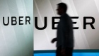 A man passes an illuminated screen bearing the Uber Technologies Inc. logo in this arranged photograph in London, U.K., on Tuesday, June 26, 2018. Uber won an 15-month probationary license to operate in London after convincing a judge and regulators that the ride-sharing service had shaken off its gung-ho attitude of the past. Photographer: Chris Ratcliffe/Bloomberg