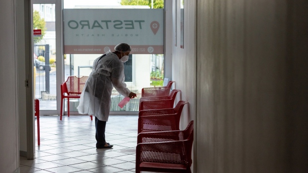 A health worker sanitizes seating in the reception area of a Testaro Covid-19 testing site in the Goodwood district of Cape Town, South Africa, on Thursday, Dec. 2, 2021. South Africa announced the discovery of a new variant, later christened omicron, on Nov. 25 as cases began to spike and the strain spread across the globe. Photographer: Dwayne Senior/Bloomberg